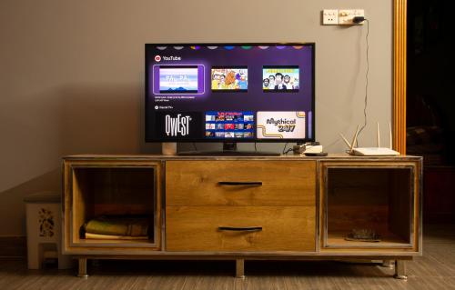 a television on top of a wooden entertainment center at The Mountain Retreat, Muzaffarabad - Families Only in Muzaffarabad