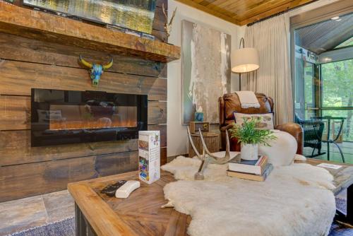 un salon avec une cheminée et une table dans l'établissement River Cottage of Blue Ridge - Outdoor Lounge with Gorgeous Views + a Hot Tub and Firepit!, à Blue Ridge