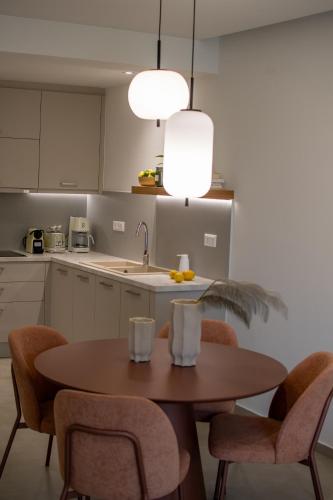 a kitchen with a table with chairs and a sink at Aigis Skiathos in Skiathos Town