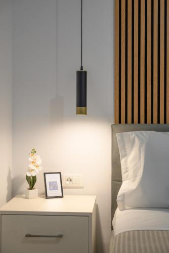a bedside table with a picture on it next to a bed at Grecian I in Agios Nikolaos