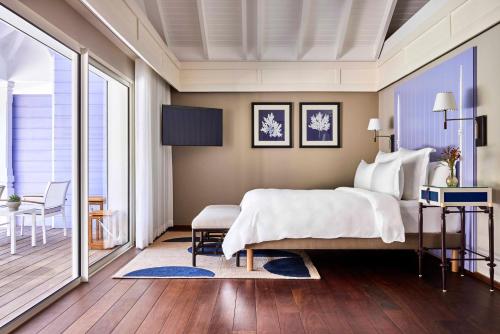a bedroom with a large bed and a balcony at Rosewood Le Guanahani St Barth in Marigot