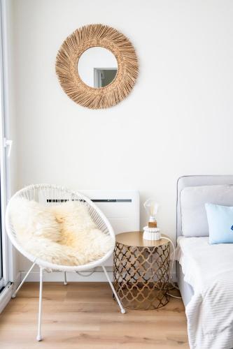 a bedroom with a rattan chair and a mirror at Vue Panoramique sur Bassin,Piscine et terrasse in Arcachon
