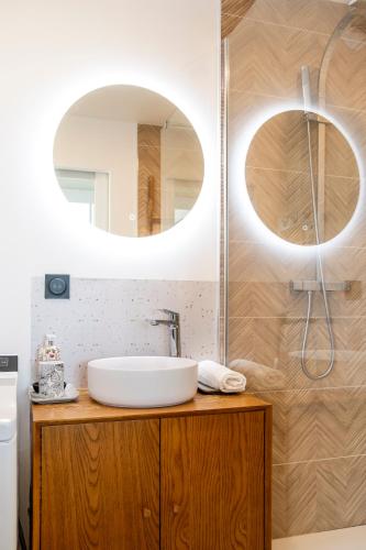 a bathroom with a sink and a mirror at Vue Panoramique sur Bassin,Piscine et terrasse in Arcachon