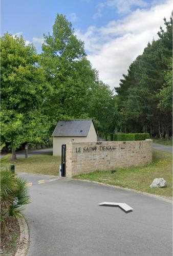 un bâtiment avec un panneau sur le côté d'une route dans l'établissement Écrin Neuf au Cœur du Golf, à Saint-André-des-Eaux