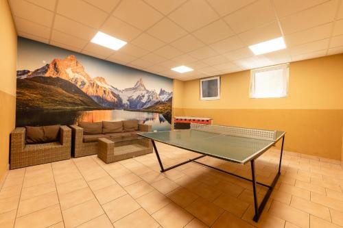 a ping pong table in a room with a couch at Aparthaus Camping Stubai in Neustift im Stubaital