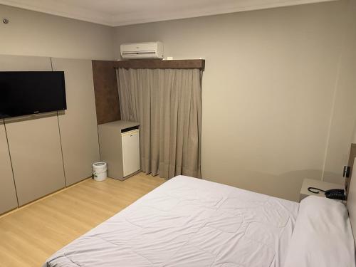 a bedroom with a white bed and a television at ibis Styles Presidente Prudente Portal D'Oeste in Presidente Prudente