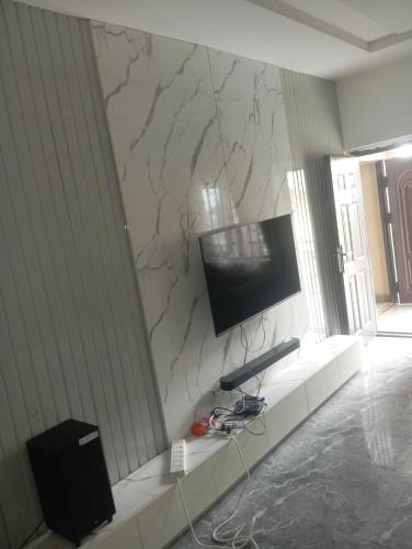 a living room with a tv on a marble wall at Luxury 2 Bedroom Flat at Independence Layout in Enugu