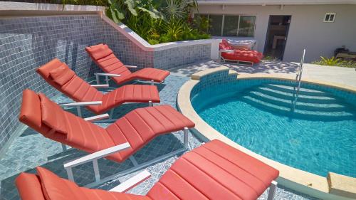 a group of red chairs and a swimming pool at AmazINN Places Luxury Villa El Cangrejo in Panama City