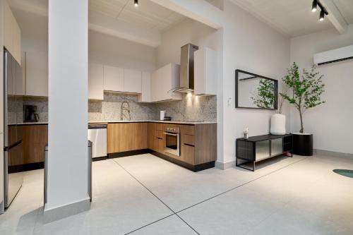 a kitchen with white walls and wooden cabinets at AmazINN Places Luxury Villa El Cangrejo in Panama City