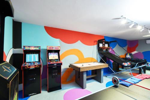a room with two arcade games and a table at AmazINN Places Luxury Villa El Cangrejo in Panama City