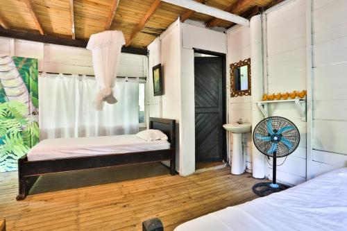 a bedroom with a bed and a fan in a room at Taironaka Eco Hotel in Don Diego