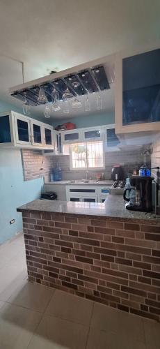 a kitchen with a brick counter in a room at Close to the sea and airport in La Golondrina