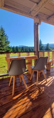 two chairs and a table on a wooden deck at Etno SELO Uskoci in Uskoci