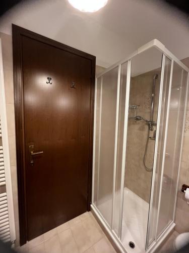 a bathroom with a shower and a brown door at Casa Izabella in Tarvisio