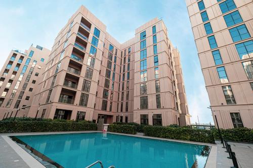 a large building with a swimming pool in front of it at The Boutique Studio at Al Mamsha, Sharjah in Sharjah Intl
