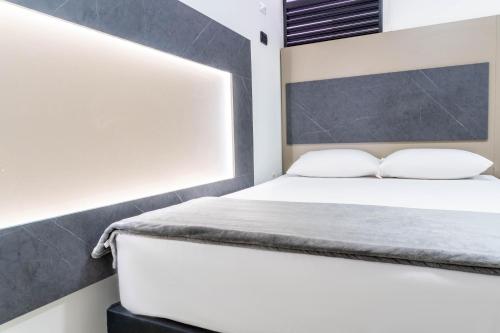 a bedroom with a bed with two pillows at ApartaHotel Estadio in Medellín