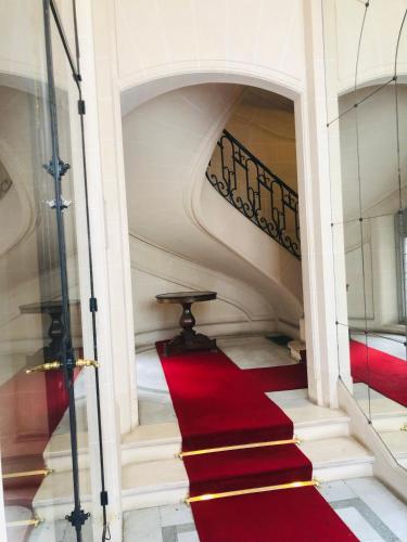 - un escalier de moquette rouge dans un bâtiment doté d'un tapis rouge dans l'établissement Vue Tour Eiffel et 5 minutes des Champs-Elysees Appartement 2 chambres Paris 16 Etoile, à Paris