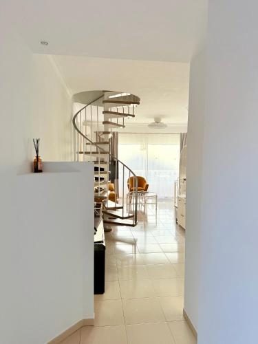 Un pasillo con escalera de caracol en una casa. en Sunny penthouse in Golf del Sur, en San Miguel de Abona