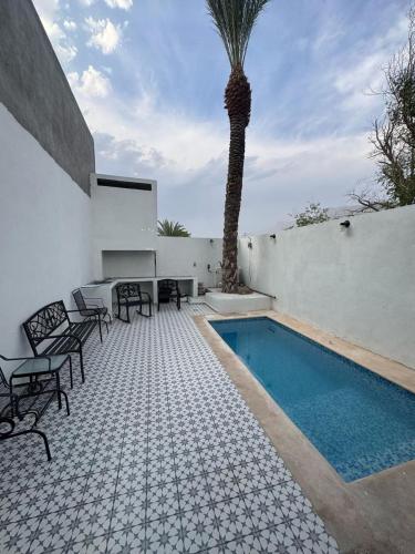 un patio con una palmera y una piscina en Casa Sererno I, en Cuatrociénegas de Carranza