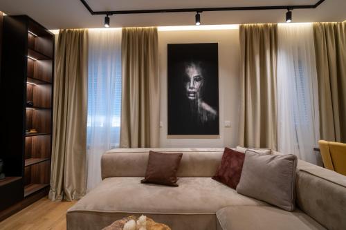 a living room with a couch and a picture of a woman at Sonrisa Apartments Kolasin in Kolašin