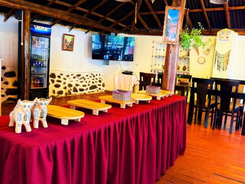 a red table with wooden benches on top of it at Andenes del Inca Hotel in Ollantaytambo