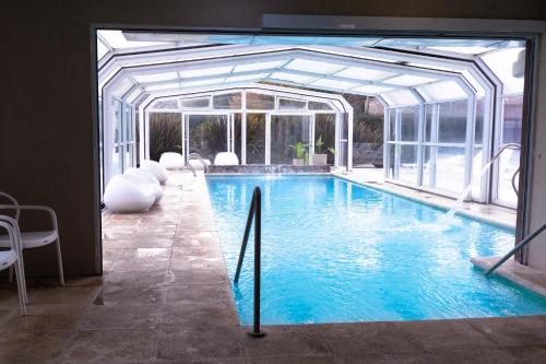 a large swimming pool with an open structure at Altos de Tandil Hotel Boutique & Spa in Tandil
