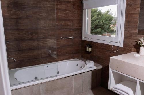 a bathroom with a bath tub and a window at Altos de Tandil Hotel Boutique & Spa in Tandil