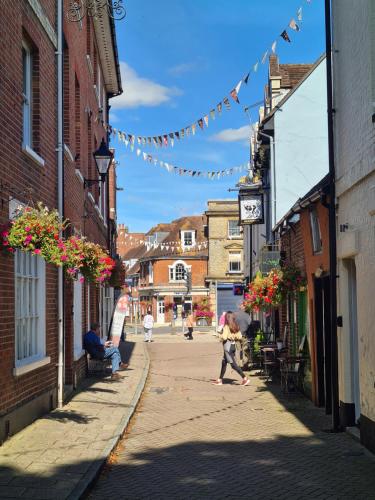 a woman walking down a street in a town at West Street Views #1 - Beautiful town centre apartment in Wimborne Minster