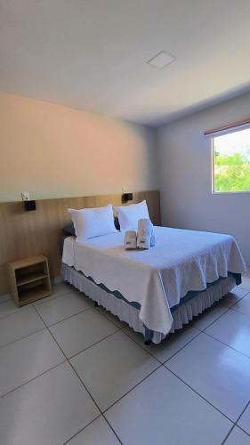 a bedroom with a bed with two towels on it at Pousada HAI in Fernando de Noronha