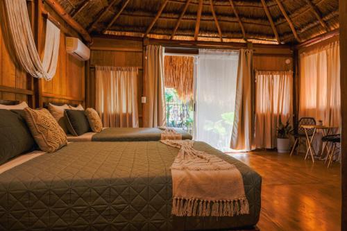 a bedroom with a bed and a large window at Bolontikú in Bacalar