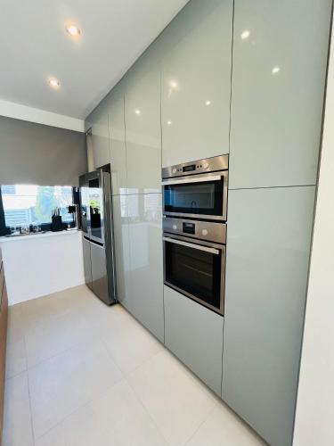 a kitchen with white walls and stainless steel appliances at House in Pezinok with swimming pool, Bratislava in Pezinok