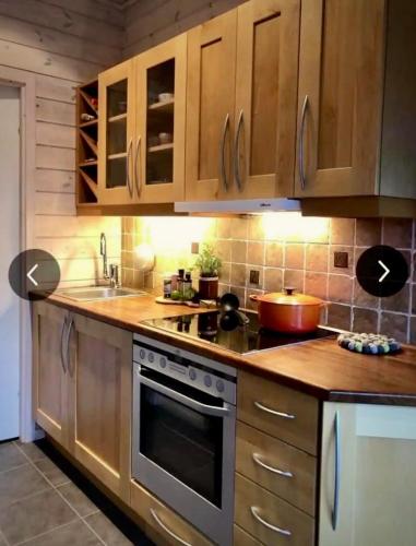 a kitchen with wooden cabinets and a stove top oven at Cozy Apartment near alpine and trails in Sirdal in Sinnes