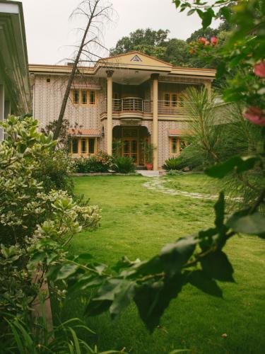 a large house with a lawn in front of it at The Mountain Retreat, Muzaffarabad - Families Only in Muzaffarabad