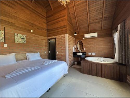 a bedroom with a bed and a bath tub at Pousada Casarão Gastehaus in Pomerode