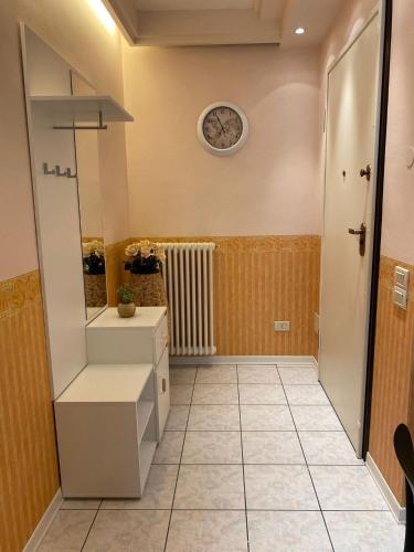 a bathroom with a sink and a clock on the wall at Maison Prestige in Monfalcone