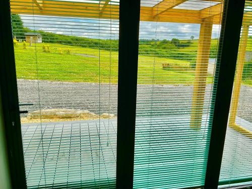 a window with a view of a field behind it at The Jeep House in the Area of Outstanding Natural Beauty in Liskeard