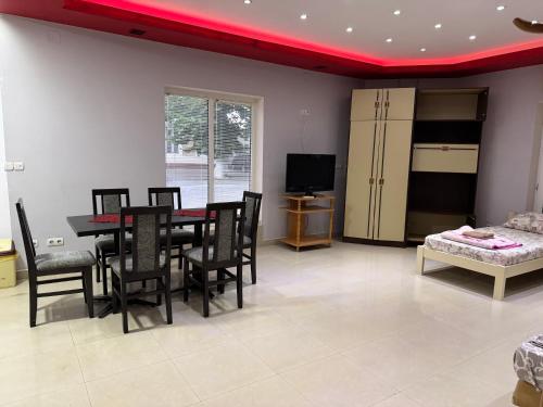 a dining room with a red ceiling and a table and chairs at Vila Fontana - Sobe in Bela Crkva