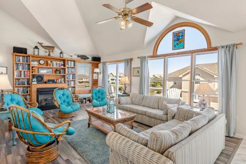 a living room with a couch and chairs and a fireplace at SeaClusion in Corolla
