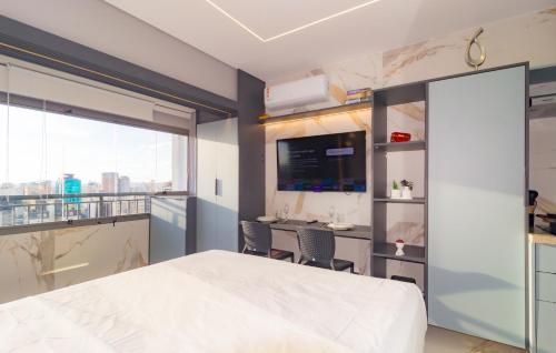 a bedroom with a bed and a desk with chairs at Prime Grand Vitrali Moema in Sao Paulo
