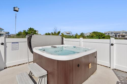 a jacuzzi tub on the balcony of a house at SeaClusion in Corolla
