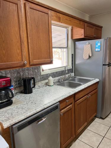 a kitchen with a sink and a refrigerator at Centrally located Cozy Mid-Century Home in McComb