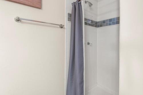 a shower with a purple shower curtain in a bathroom at SeaClusion in Corolla