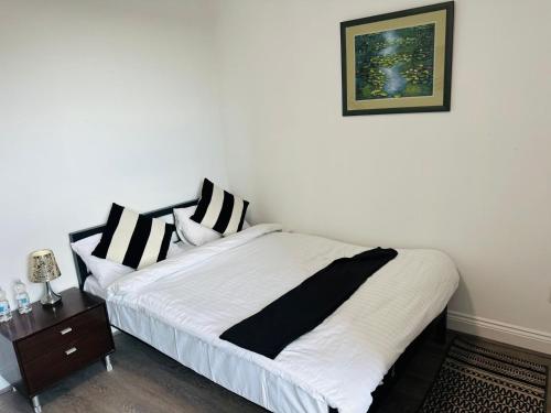 a bedroom with a bed with black and white pillows at Sterling Bed & Breakfast in Ilford