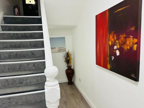 a staircase with a painting and a vase in a room at Sterling Bed & Breakfast in Ilford