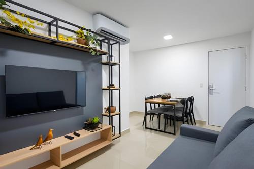 a living room with a couch and a tv on a wall at Haus Smart Living Recife in Recife