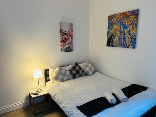 a bedroom with a bed and a painting on the wall at Sterling Bed & Breakfast in Ilford