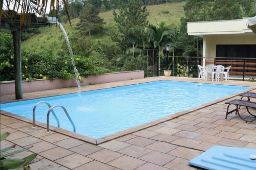 a swimming pool with a water fountain at Pousada Casarão Gastehaus in Pomerode