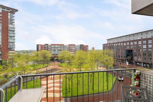 a balcony with a view of a park and buildings at A Cozy and Nice Furnished Room in Shared Modern Apartment in Barendrecht