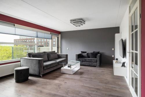 a living room with two couches and a tv at A Cozy and Nice Furnished Room in Shared Modern Apartment in Barendrecht