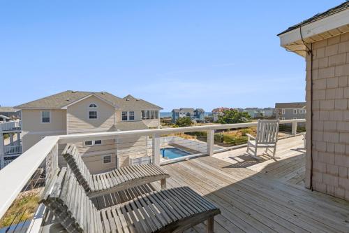 a deck with a bench and a view of the ocean at SeaClusion in Corolla